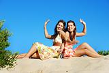 Two young woman having fun on the beach on a summer day