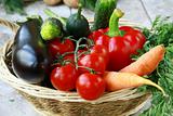 Different fresh vegetables in a wicker basket on the table