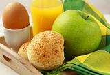 breakfast with orange juice, boiled egg and sesame buns and  green apple