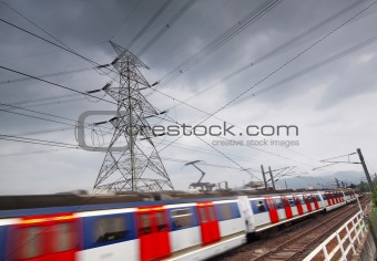 passenger trains in motion and power tower on background