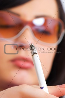 Young girl smoking - focus on the cigarette