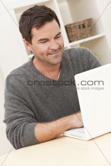 Man Using Laptop Computer At Home 