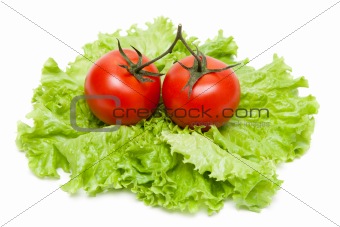 Two ripe tomatoes on sheet of the salad