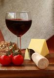 cheese plate with cherry tomatoes, bread and a glass of wine