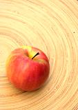 Red apple on a bamboo plate