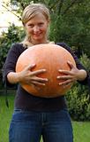 Girl holding huge pumpkin