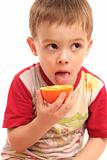 The boy eats a tasty juicy orange