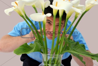 Man peeking through flowers