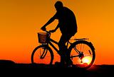Man and bike silhouette in orange sunrise