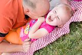 Loving Dad Tickles His Daughter in the Park.