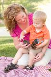 Attractive Mother and Adorable Son Talk about Pine Cones in The Park.