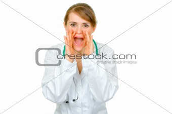 Cheerful medical doctor woman shouting through megaphone shaped  hands
