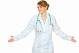 Confused young medical doctor woman spreading hands apart
