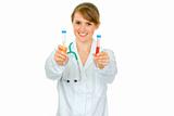 Smiling medical doctor woman holding test tubes in hand
