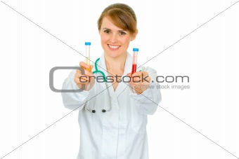 Smiling medical doctor woman holding test tubes in hand
