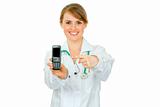 Smiling medical female doctor pointing finger on mobile with blank screen

