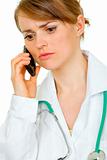 Worried medical female doctor talking on mobile phone
