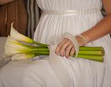 Bride holding flowers while sat down