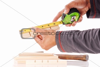 Hands Measuring a Piece of Pine Wood
