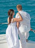 Newly married couple stood on the bow of a boat