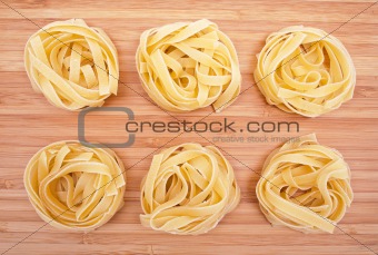 Tagliatelle on the wooden background