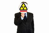  radiation danger! Businessman holding  radiation sign in front of face
