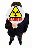 Ð¡oncept-radiation danger! Businessman holding  radiation sign in front of face
