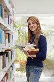 girl choosing book in library and smiling
