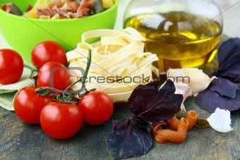 Italian Pasta with tomatoes, olive oil and basil on wooden background