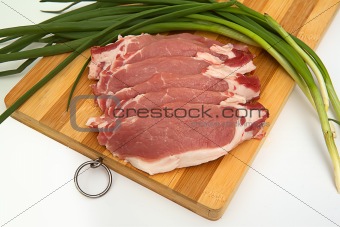 Plate of raw meat with onions on bamboo board