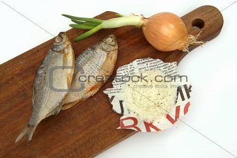 Dried fish, onions and salt on a board