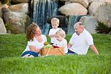 Happy Adorable Young Family with Twins Enjoy a Picnic in the Park.