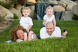 Happy Young Adorable Family with Twins Portrait on Grass in the Park.