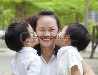 Happy mothers day. two kids kissing mother