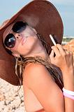 attractive woman in a hat smoking a cigarette