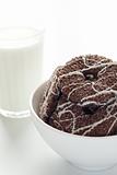 A glass of milk and tasty cookies on a white plate
