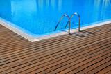 blue swimming pool with teak wood flooring