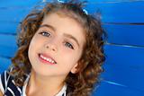 children little girl smiling on wooden blue wall