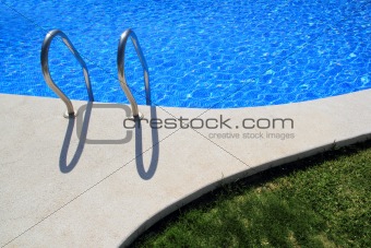 blue tiles swimming pool with green grass garden