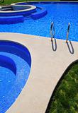 blue tiles swimming pool with green grass garden