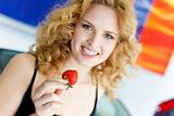 Young woman with strawberry near New car