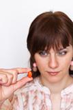 A young girl holding a orange pill