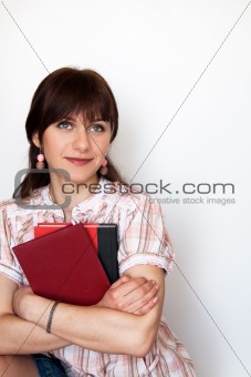 A beautiful young student holding books and smiling