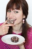 Young beautiful brunette eating delicious chocolate chip cookies