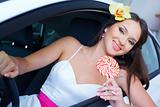 Young woman with candy with New car