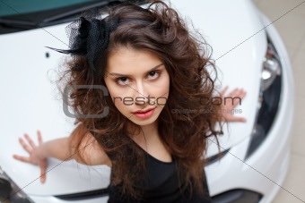 Young woman on white hood of New car