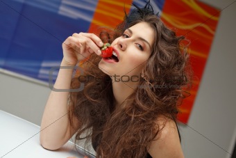Young woman with red strawberry on roof of New car