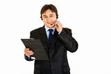 Cheerful young businessman with headset holding clipboard
