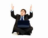 Sitting with laptop on floor businessman looking up and raising his hands
