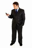 Full length portrait of businessman holding mobile in hand and looking on it

